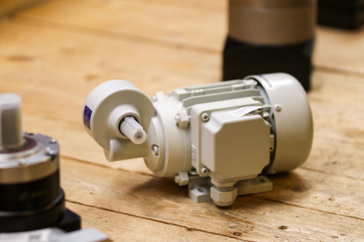 Small electric gearmotor with attached gearbox on a workshop bench